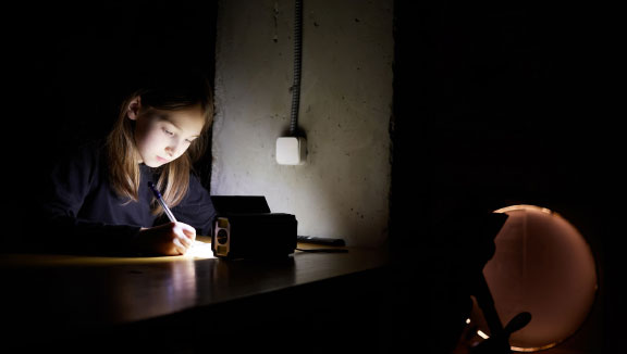 Dunkelheit: Mädchen schreibt mit Licht vom Handy