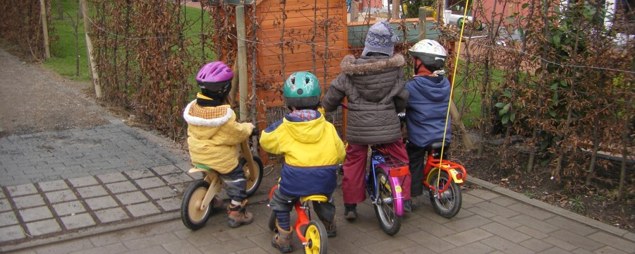 Kinder mit Dreirädern im autofreien Wohngebiet 