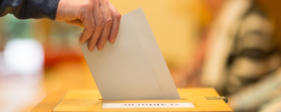 Wahlurne: Wahlzettel wird eingeworfen