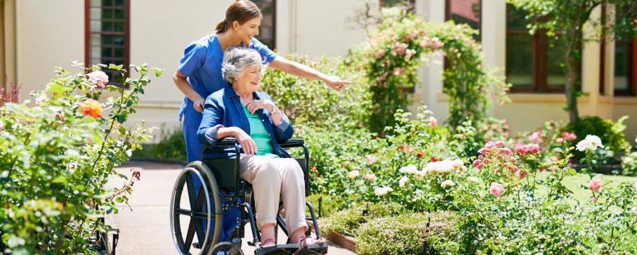 Altenheim: Ältere Dame mit Pflegerin im Garten
