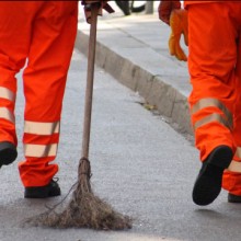 Arbeitspflicht: Zwei Arbeiter kehren die Straße.